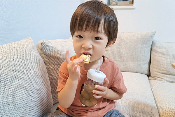 かわいいお子さんが母乳実感パーツ（ストロー）を使いながらおやつを食べているところです